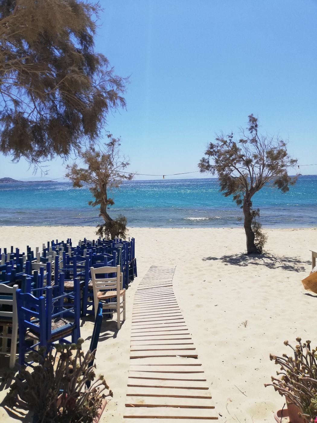 O passadiço até à praia de Plaka, entre as mesas da taberna