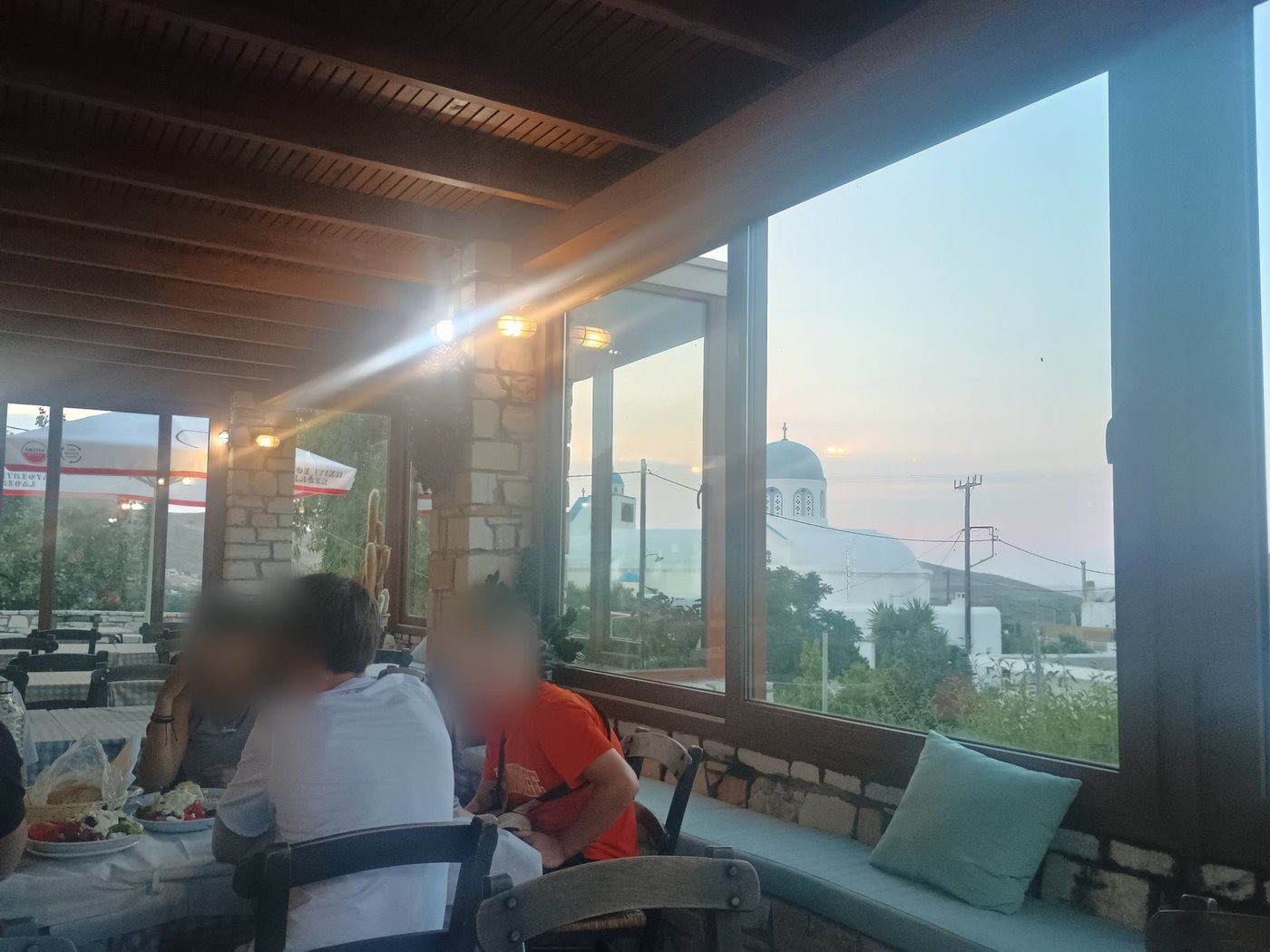 Uma mesa junto à janela de uma taverna ao pôr do sol, em Naxos