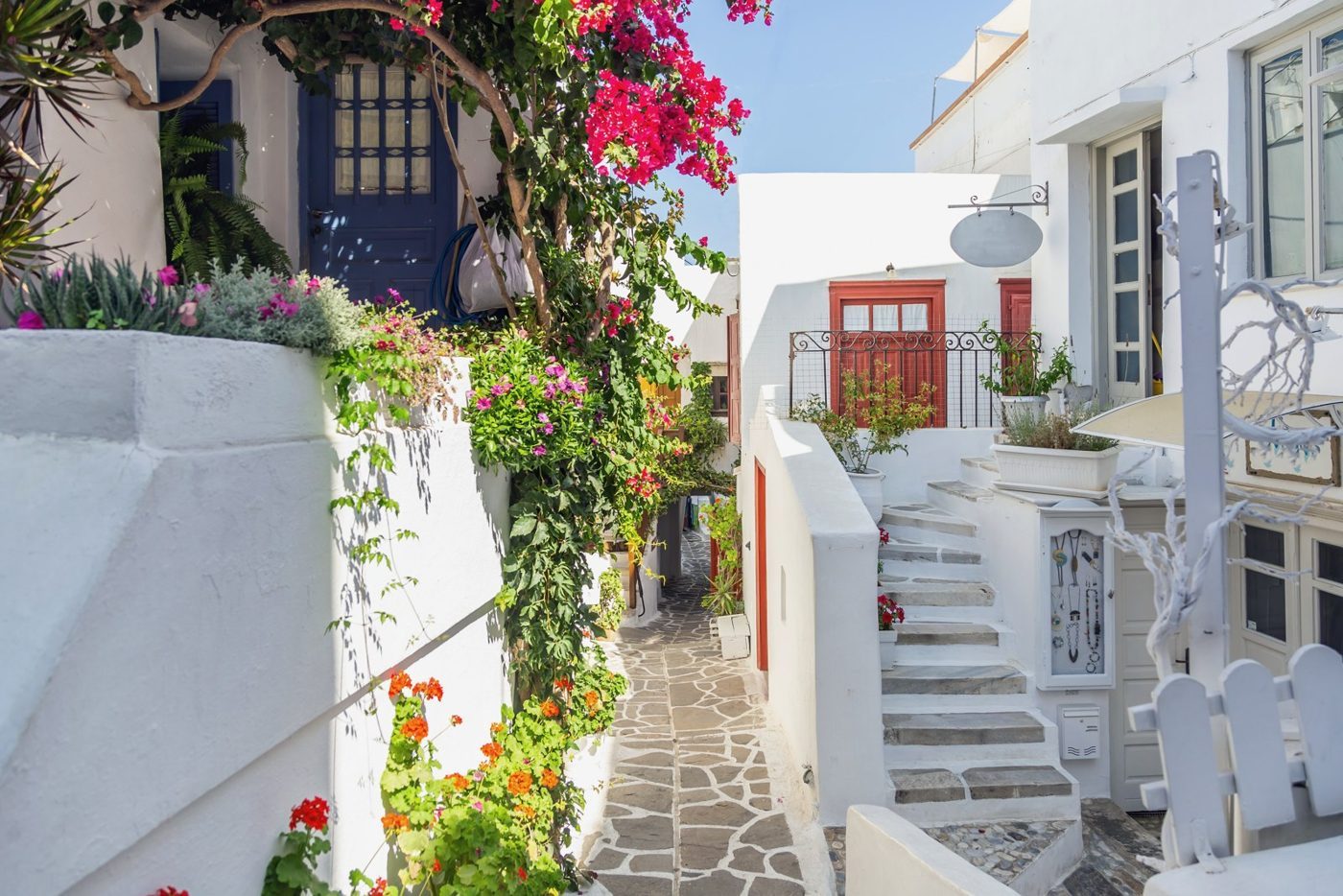 Buganvílias e casas caiadas numa ruela calcetada da cidade de Naxos