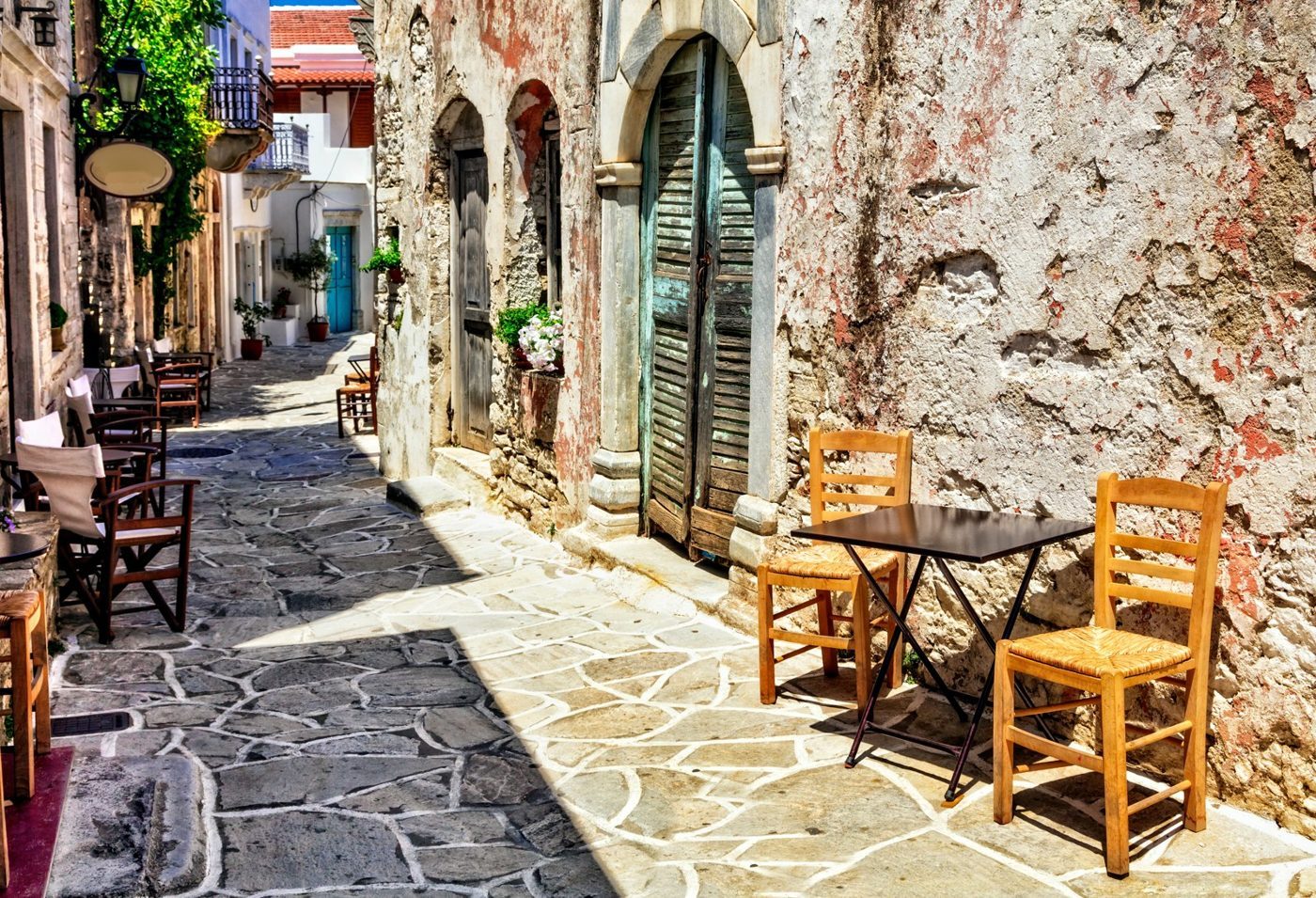 Mesas de café numa rua de pedra em Halki, a antiga capital do interior de Naxos