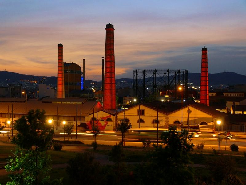 As chaminés da Technopolis ao pôr do sol, quando Gazi acorda para a noite